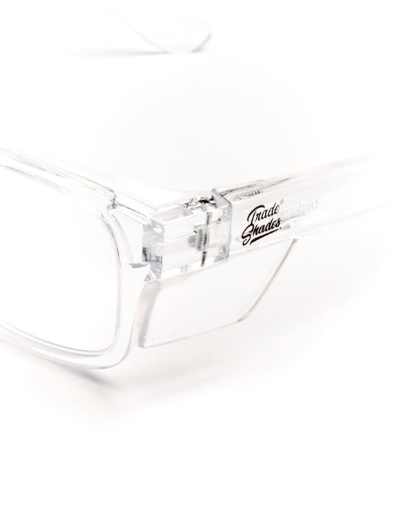Close-up detail of Trade Shades clear frame safety glasses hinge, temple and Trade Shades logo