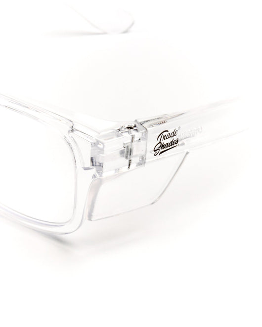 Close-up detail of Trade Shades clear frame safety glasses hinge, temple and Trade Shades logo